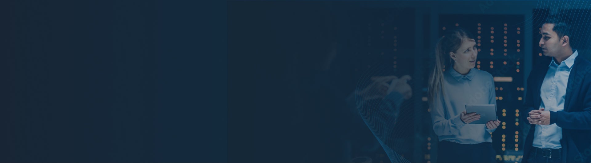 Dark blue banner with image of man talking to woman holding a tablet in hand in a server room.