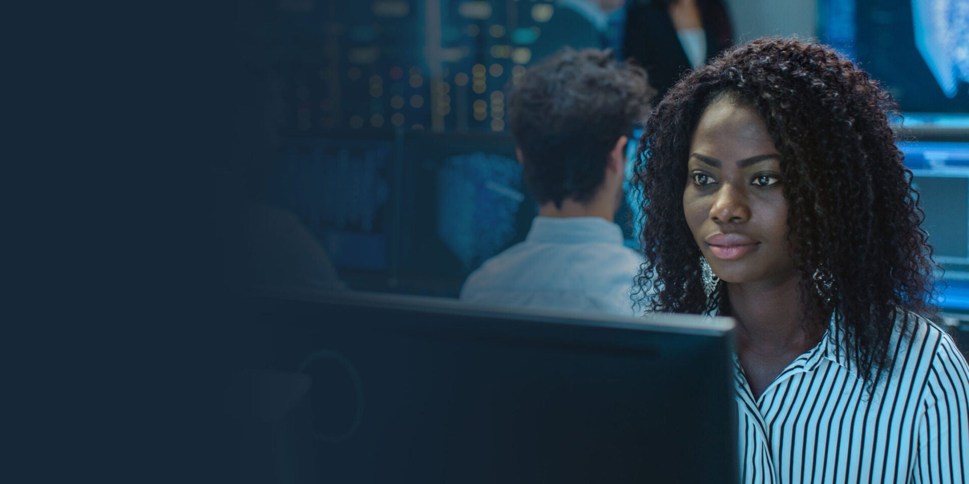 Image of woman working on her computer in control center.