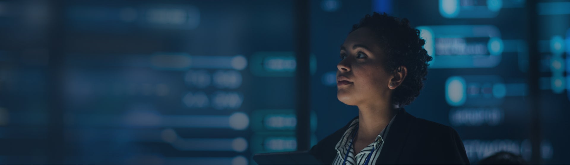 Image of woman looking up in the distance in a control center.