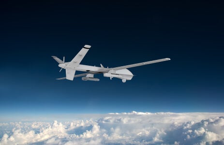 Photo of an MQ-9B SeaGuardian flying above the clouds.