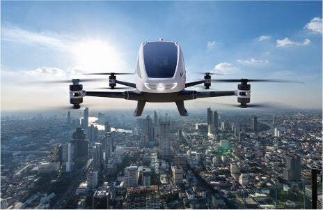 Image of a EHang passenger drone flying over a city.