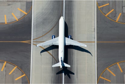 Aerial view of a commercial airplane parked in the middle of a runway.